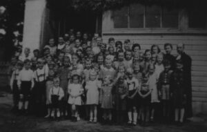 Einweihung der Kirche, Pastor Alfred Proll mit Kindern vor der Kirche, 1951